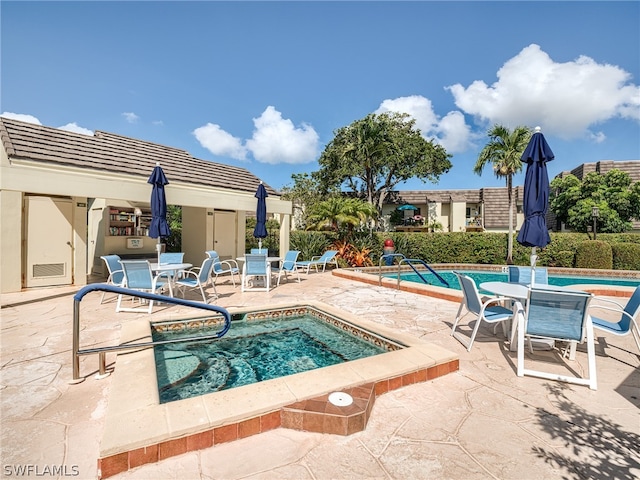 view of swimming pool featuring a patio and a hot tub