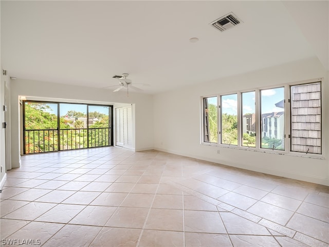 tiled empty room with plenty of natural light and ceiling fan