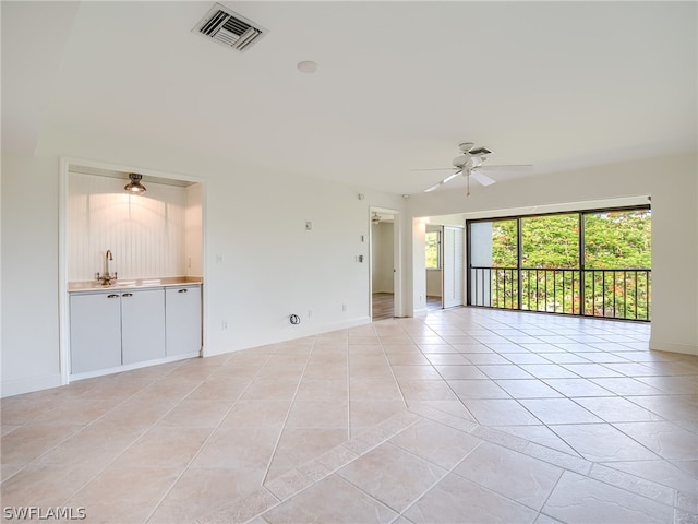 tiled empty room featuring sink and ceiling fan