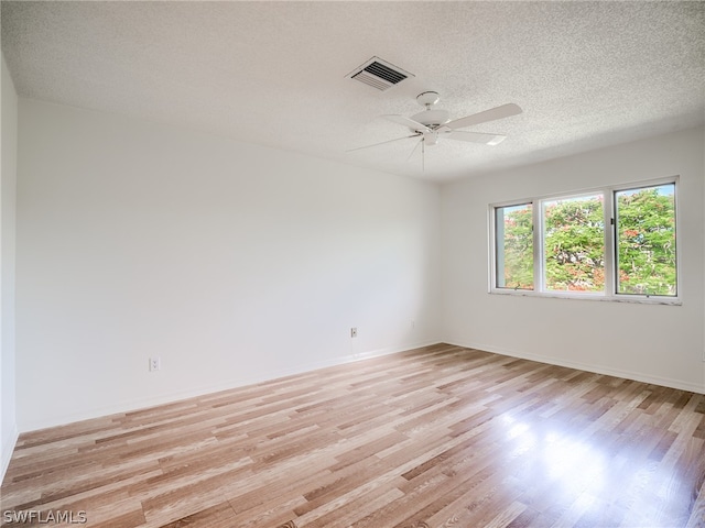 empty room with light hardwood / wood-style floors, a textured ceiling, and ceiling fan