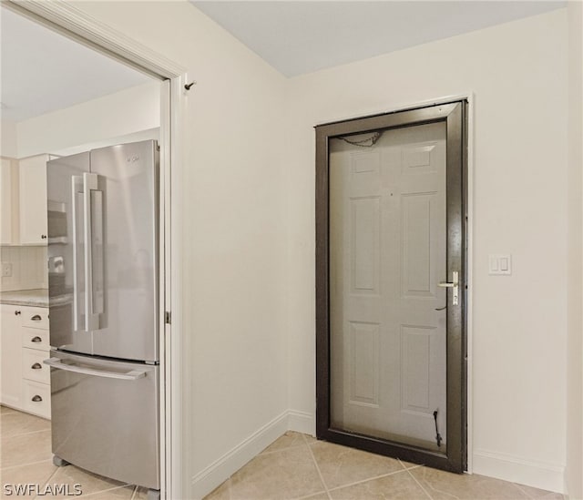 kitchen featuring light tile patterned floors, high end refrigerator, and white cabinets