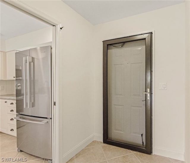 interior space featuring baseboards and light tile patterned floors