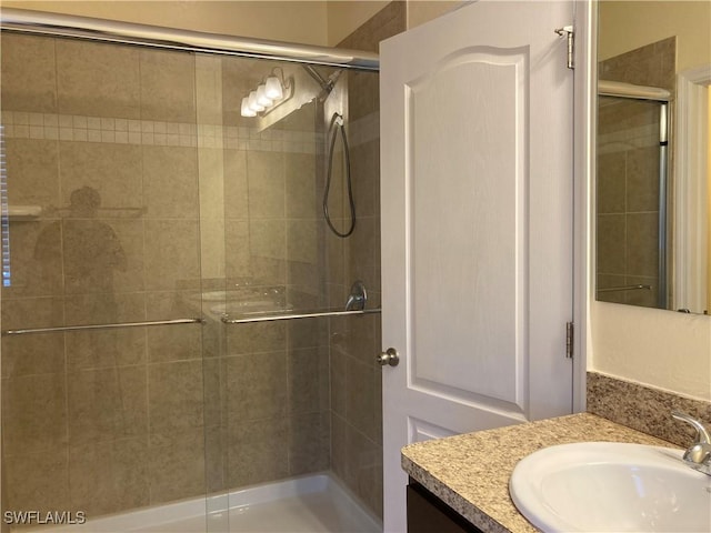 bathroom with vanity and a shower with door