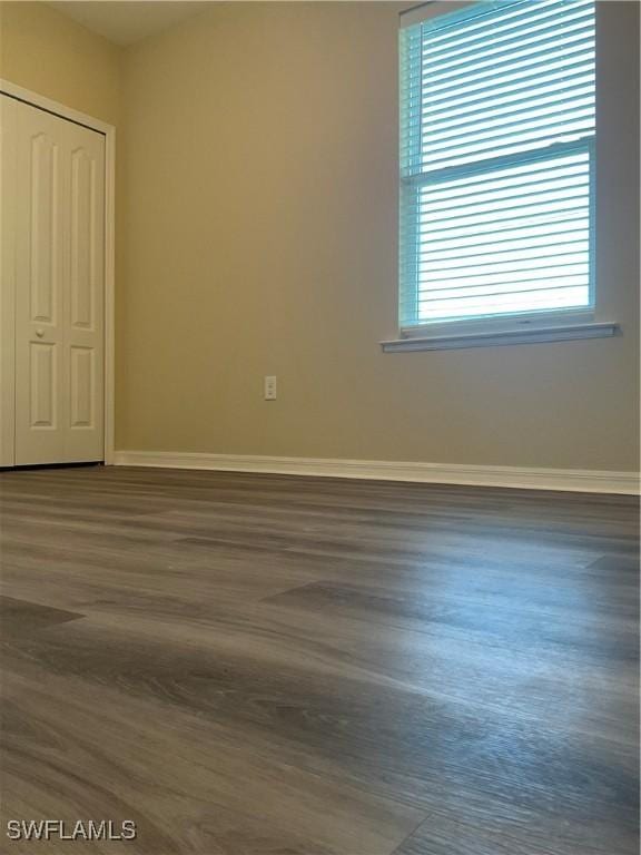 unfurnished bedroom featuring dark hardwood / wood-style floors and a closet