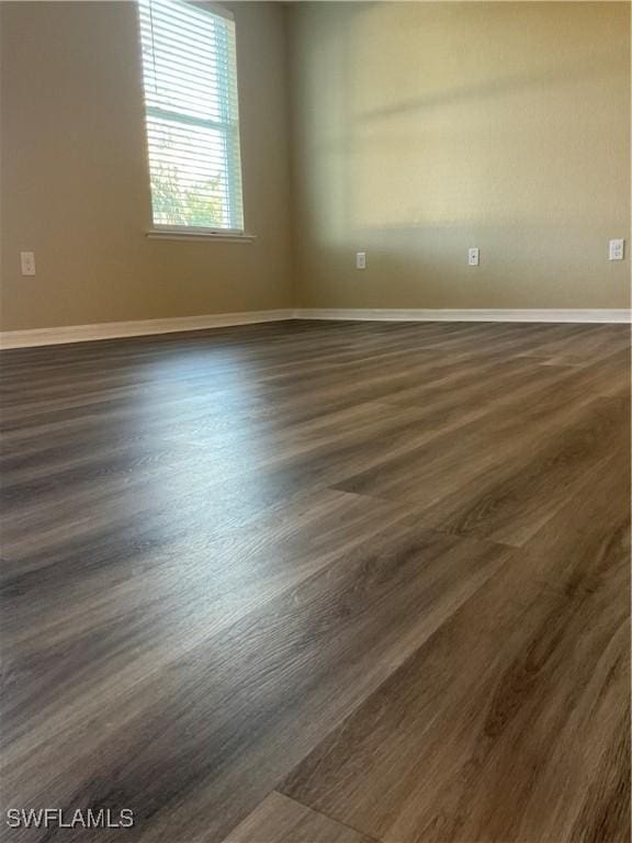 unfurnished room with dark wood-type flooring