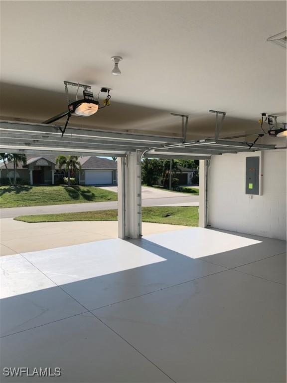 garage featuring electric panel and a garage door opener