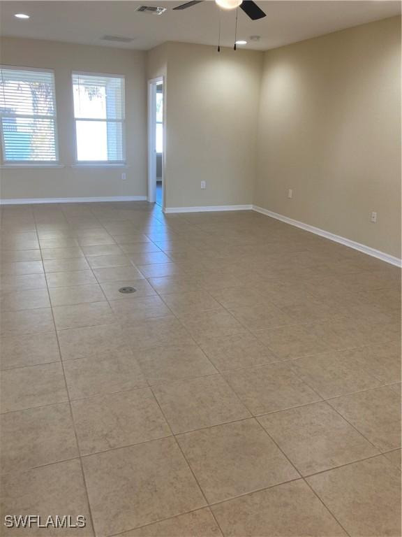 spare room with ceiling fan and light tile patterned floors