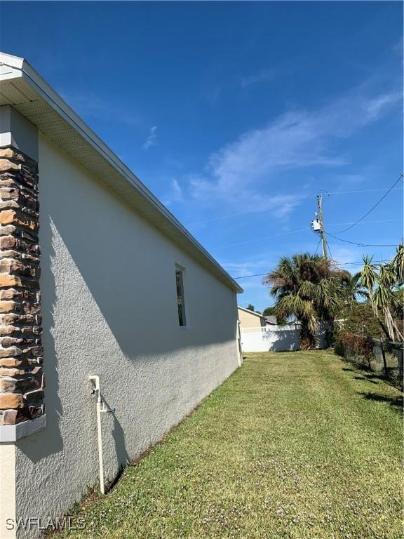 view of side of property with a lawn