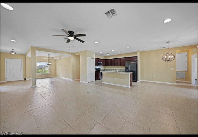 unfurnished living room featuring sink, ceiling fan with notable chandelier, and light tile patterned floors