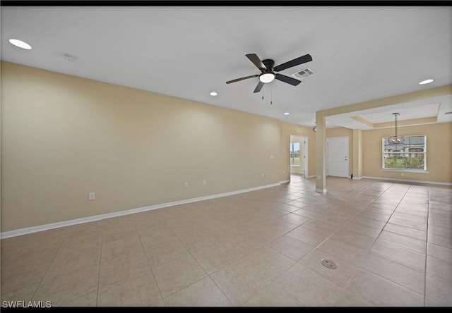 tiled spare room with a tray ceiling, a wealth of natural light, and ceiling fan