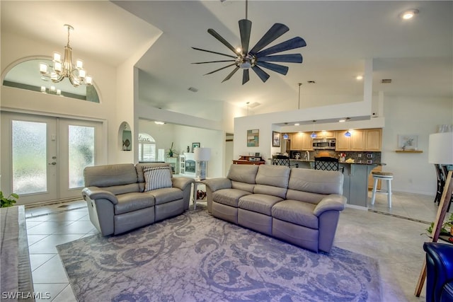 tiled living room featuring ceiling fan with notable chandelier, french doors, and lofted ceiling