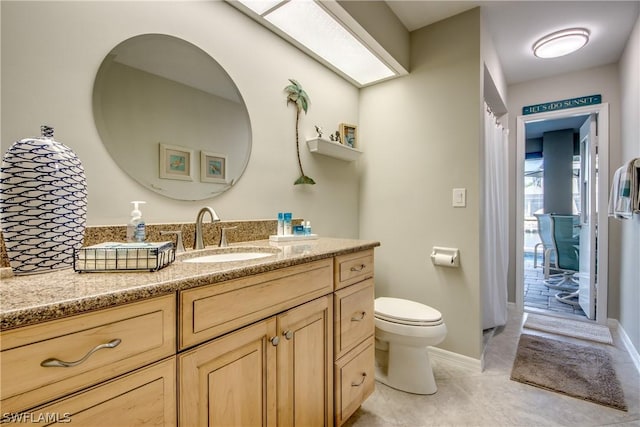 bathroom with toilet, vanity, and tile patterned flooring