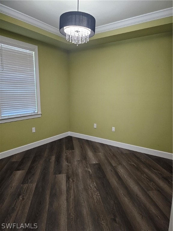 spare room with ornamental molding, a notable chandelier, and wood-type flooring