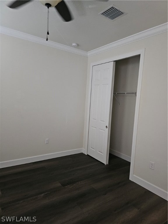 unfurnished bedroom featuring a closet, crown molding, ceiling fan, and dark wood-type flooring