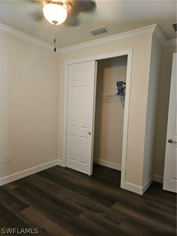 unfurnished bedroom featuring ceiling fan, a closet, crown molding, and dark hardwood / wood-style floors