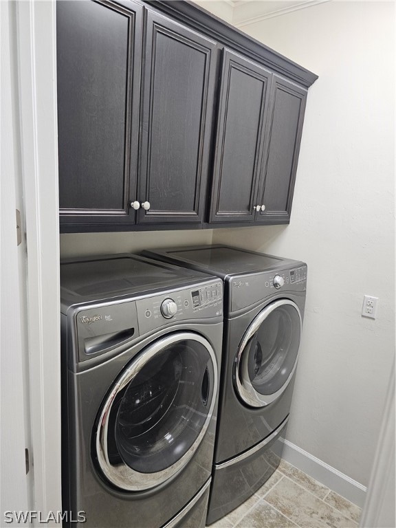 washroom featuring cabinets, independent washer and dryer, and light tile patterned floors