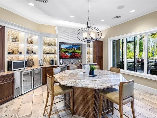 dining room with an inviting chandelier, beverage cooler, and crown molding