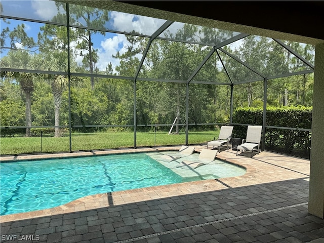 view of swimming pool with a patio area and a lanai