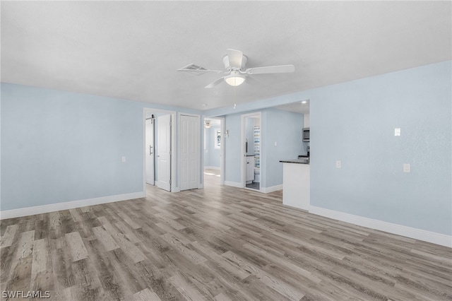 unfurnished living room with ceiling fan and light hardwood / wood-style floors