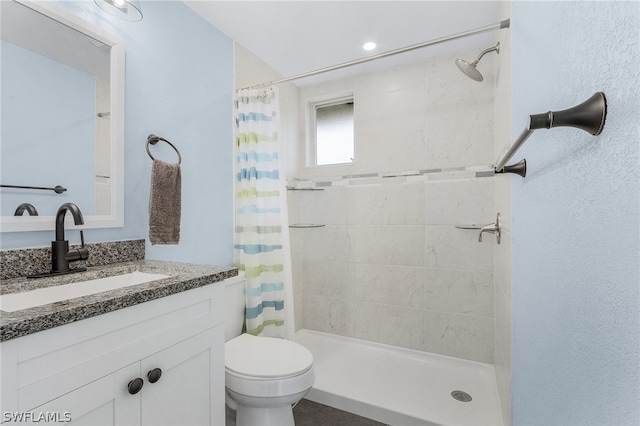 bathroom with walk in shower, vanity, and toilet