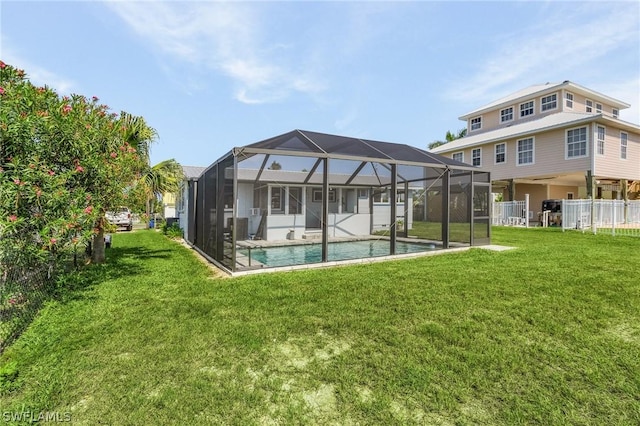 back of property featuring a fenced in pool, glass enclosure, and a lawn