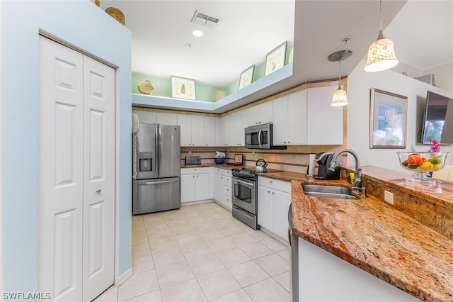 kitchen featuring tasteful backsplash, pendant lighting, stainless steel appliances, and white cabinetry