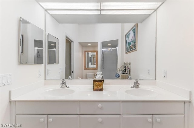 bathroom with toilet, a shower with door, and vanity