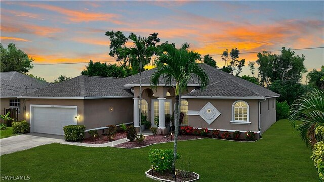 view of front of property featuring a garage and a lawn