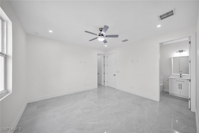 unfurnished bedroom featuring ceiling fan, connected bathroom, and light tile patterned floors