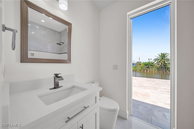 bathroom featuring tile patterned flooring, toilet, and vanity