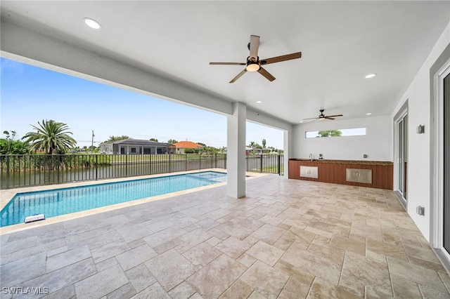 view of swimming pool featuring ceiling fan and a patio area