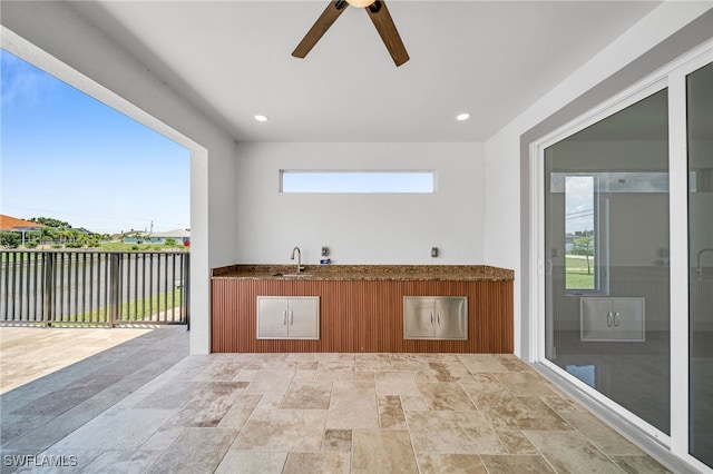 view of patio with ceiling fan and sink