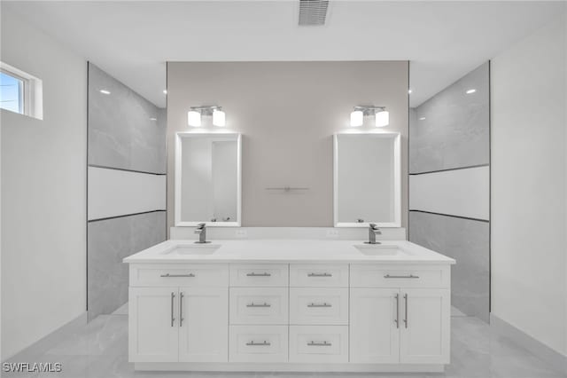 bathroom featuring tile walls, tile patterned flooring, and double sink vanity