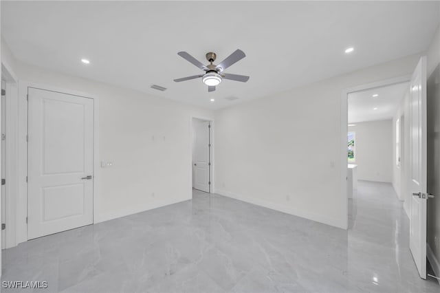 tiled spare room with ceiling fan