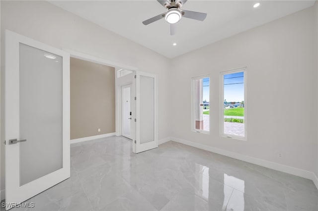 spare room with ceiling fan and light tile patterned floors