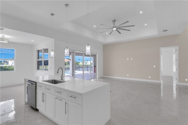 kitchen featuring stainless steel dishwasher, sink, a tray ceiling, ceiling fan, and light tile patterned flooring