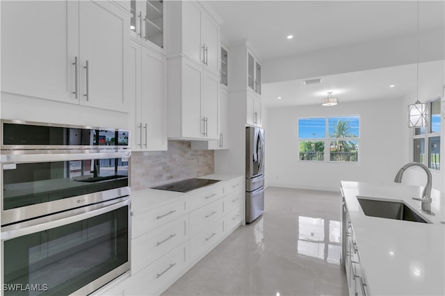 kitchen with sink, hanging light fixtures, tasteful backsplash, light tile patterned floors, and stainless steel appliances