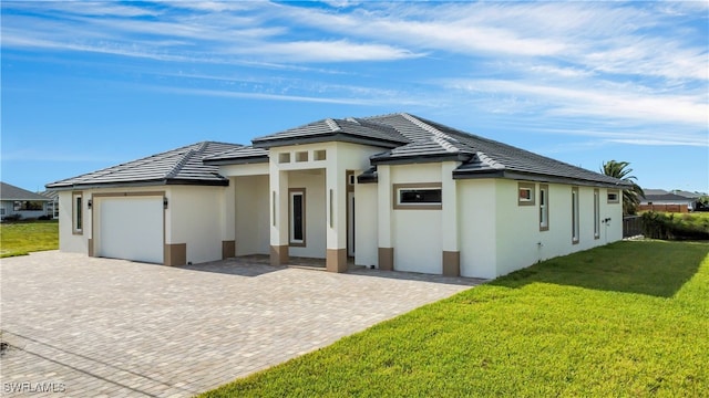 prairie-style home featuring a front yard and a garage