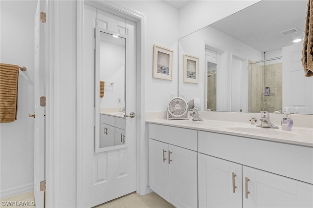 bathroom featuring a shower with shower door and vanity