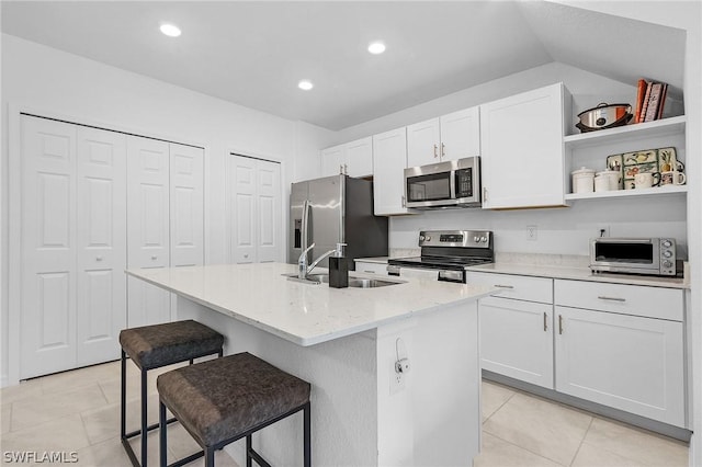 kitchen featuring white cabinetry, stainless steel appliances, an island with sink, sink, and a breakfast bar area