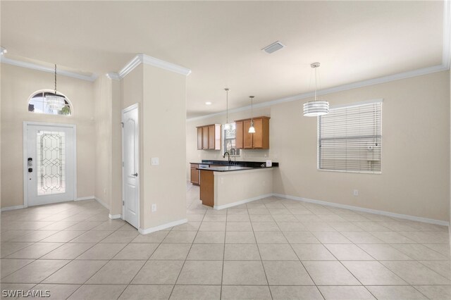 kitchen with pendant lighting, kitchen peninsula, crown molding, and light tile patterned floors