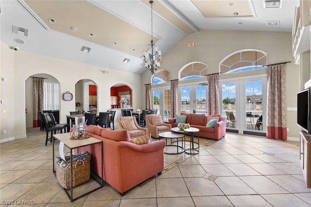 living room featuring a notable chandelier, a high ceiling, beam ceiling, french doors, and light tile patterned floors