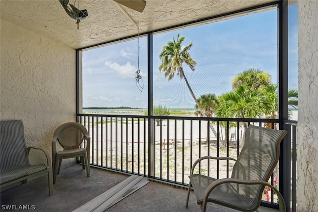 sunroom / solarium featuring a water view