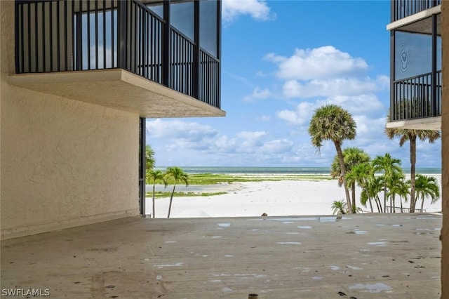 view of patio with a water view and a view of the beach