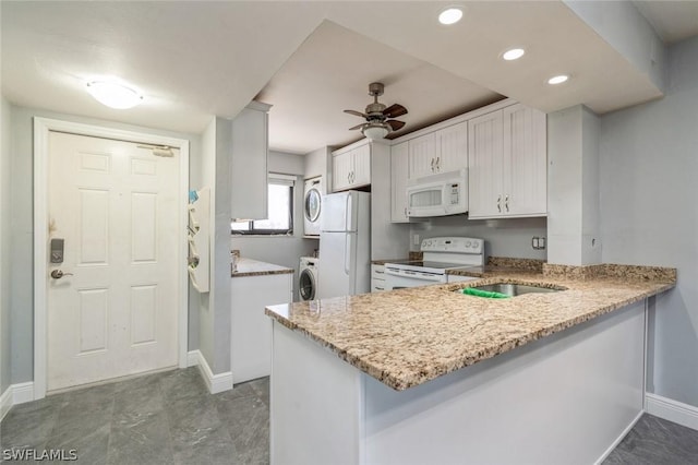 kitchen featuring white appliances, ceiling fan, white cabinetry, light stone countertops, and kitchen peninsula