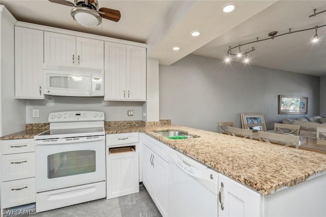 kitchen with white cabinetry, sink, kitchen peninsula, light stone countertops, and white appliances