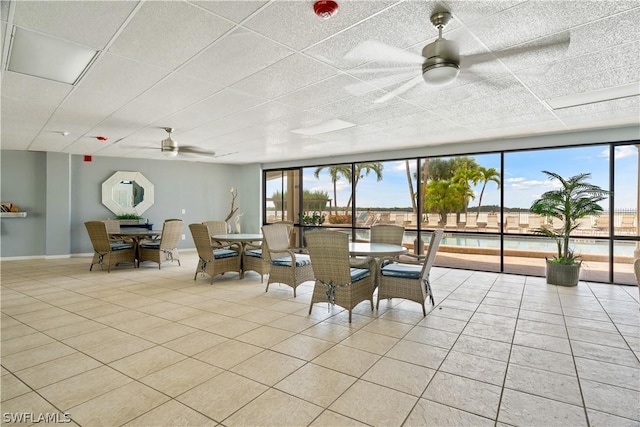 interior space featuring ceiling fan, a healthy amount of sunlight, and a paneled ceiling