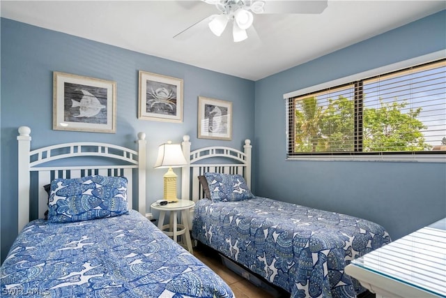 bedroom with multiple windows, dark hardwood / wood-style floors, and ceiling fan