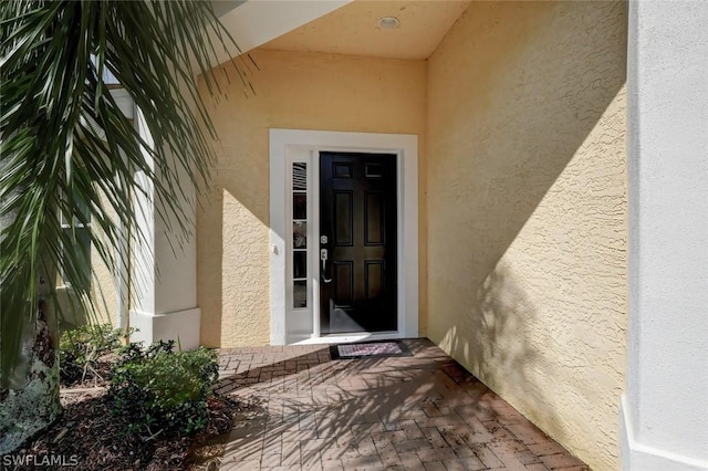 view of exterior entry featuring stucco siding