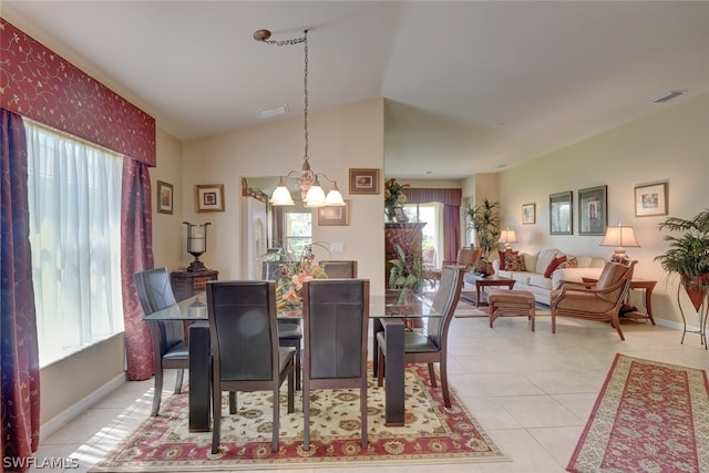 dining room featuring light tile patterned flooring, lofted ceiling, and a chandelier